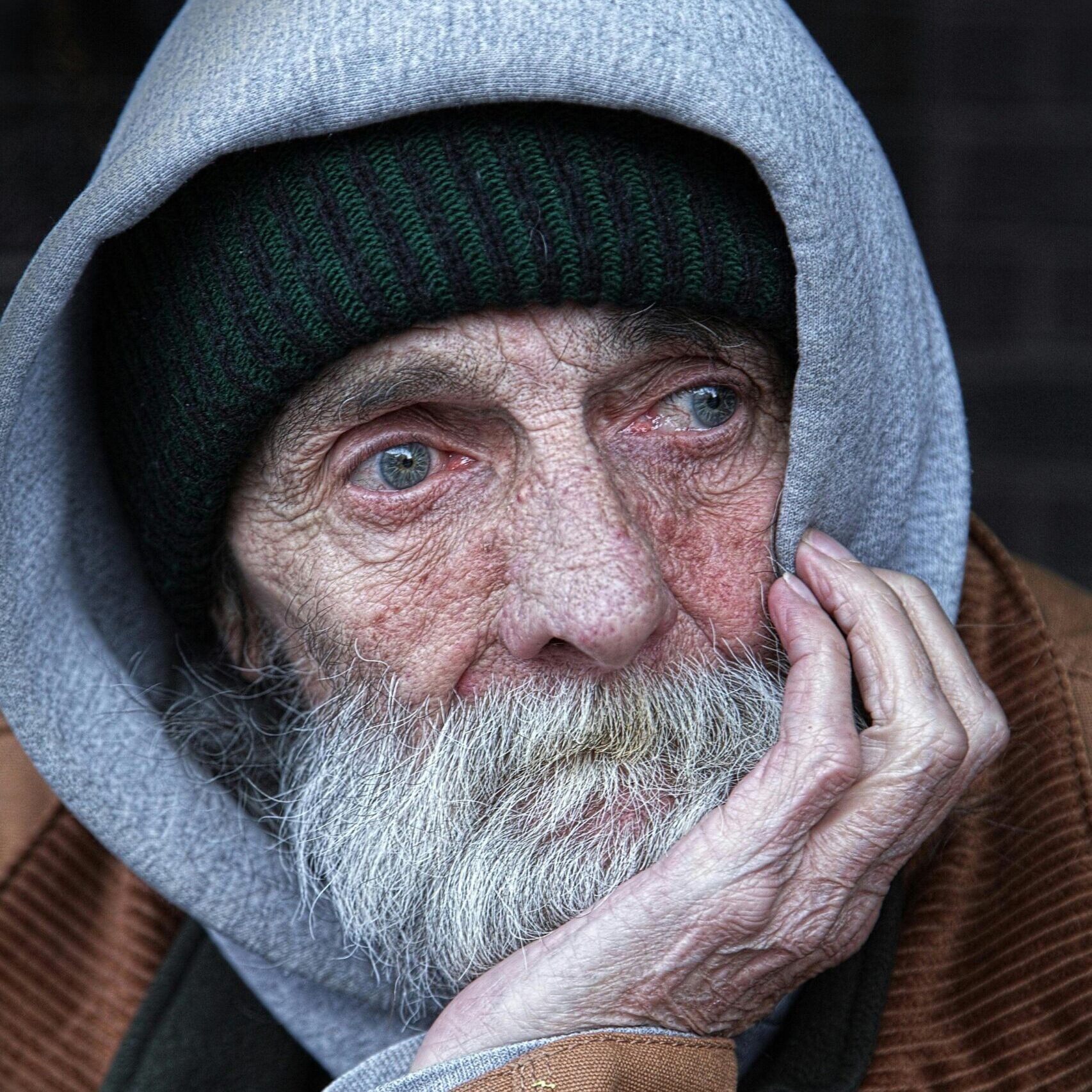Portrait of an elderly man in a hoodie, capturing the essence of thought and introspection.